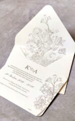 Προσκλητήριο γάμου με ανάφλυφα λουλούδια.