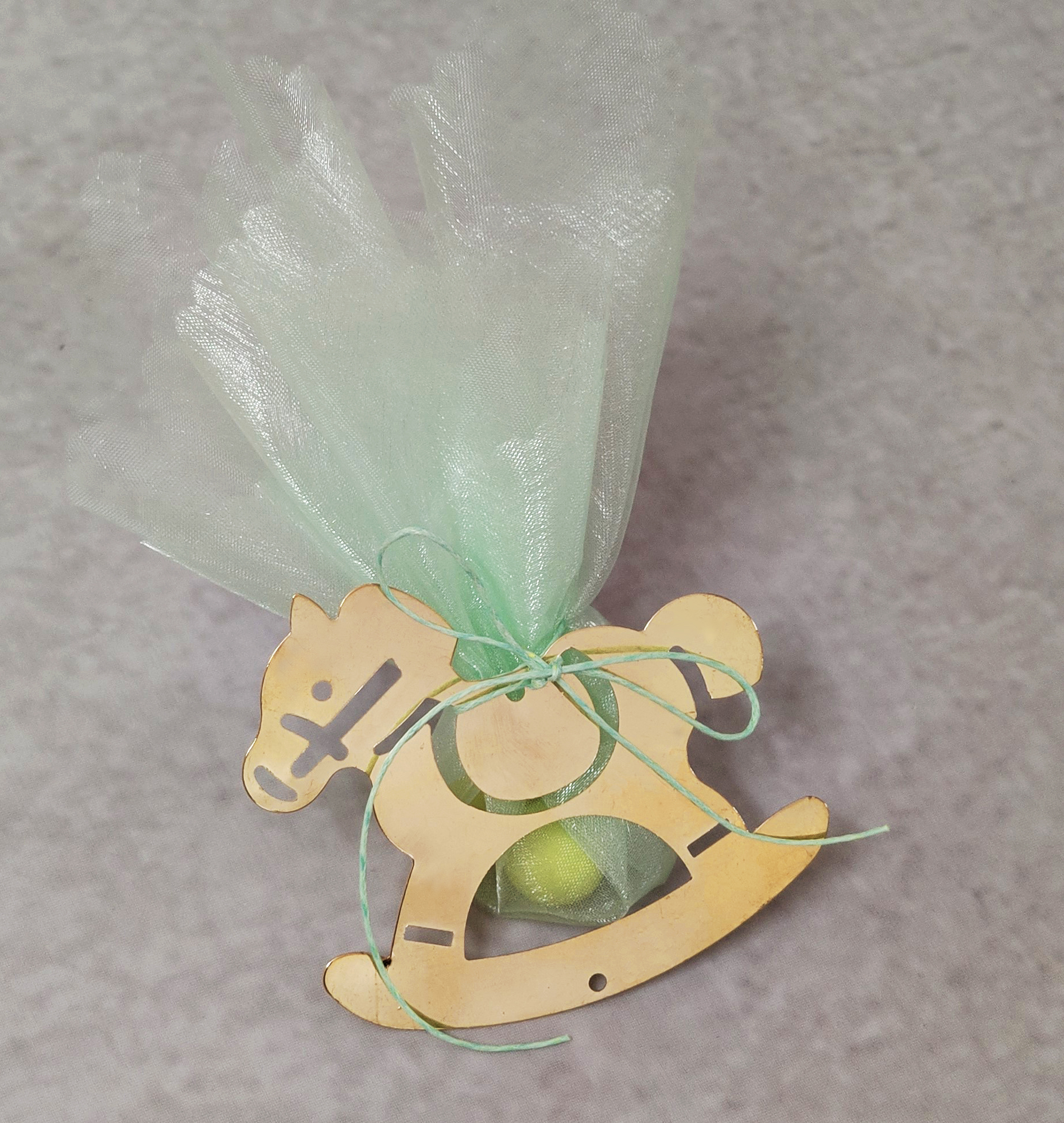 Μπομπονιέρα βάπτισης με χρυσό μεταλλικό αλογάκι σε μέντα αποχρώσεις.