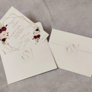 Προσκλητήριο γάμου με γεωμετρικό σχήμα και λουλούδια και φάκελος με κλείσιμο.