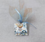 Μπομπονιέρα βάπτισης ξύλινο μπρελόκ με θέμα αερόστατο σε σοκολά τούλι και γαλάζιο δίχτυ.