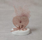 Μπομπονιέρα γάμου καρδιά από ροζ καθρέφτη plexi-glass σε βότσαλο.