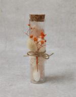 Μπομπονιέρα γάμου γυάλινος σωλήνας με αποξηραμένα λουλούδια και δαντέλα.