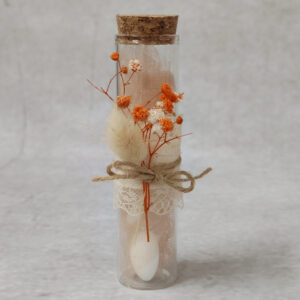 Μπομπονιέρα γάμου γυάλινος σωλήνας με αποξηραμένα λουλούδια και δαντέλα.