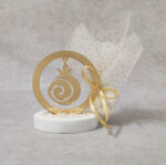 Μπομπονιέρα γάμου ρόδι από χρυσό καθρέφτη plexi-glass σε βότσαλο.