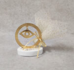 Μπομπονιέρα γάμου μάτι από χρυσό καθρέφτη plexi-glass σε βότσαλο.