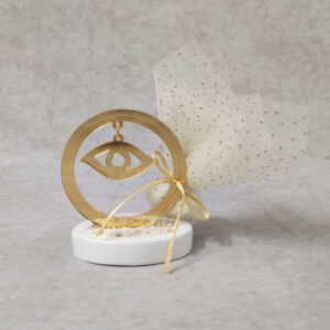 Μπομπονιέρα γάμου μάτι από χρυσό καθρέφτη plexi-glass σε βότσαλο.