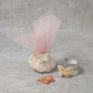 Μπομπονιέρα βάπτισης κεραμική πεταλούδα δεμένη με ροζ γκλιτερ τούλι και ροζ σατέν κορδέλα.