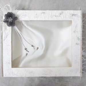 Ξύλινη στεφανοθήκη σε ασημί απόχρωση με επένδυση εσωτερικά και κορδέλες με διακοσμητικό λουλούδι και ασημί γκλίτερ.