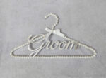 Κρεμάστρα με πέρλες, ασημί καθρέφτη plexiglass με το "Groom" και σατέν κορδέλα.