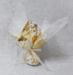 Μπομπονιέρα γάμου με δίχτυ με φύλλο χρυσού και λευκή οργάντζα εσωτερικά, δεμένη με λευκή κορδέλα οργάντζας.