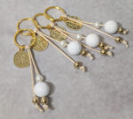 Μαρτυρικά βάπτισης μπρελόκ με λευκές και χρυσές χάντρες, σχοινί και χρυσό κωνσταντινάτο σε κουτί 50 τμχ.