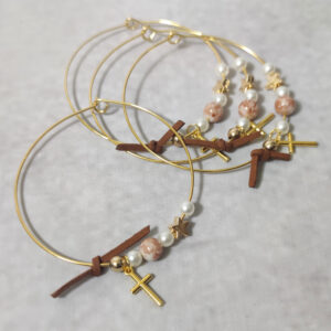 Μαρτυρικά βάπτισης μεταλλικά βραχιόλια στολισμένα με 3 λευκές πέρλες, περίτεχνη χάντρα με νερά από σοκολά απόχρωση, χρυσή χάντρα και χρυσό αστεράκι με μεταλλικό χρυσό σταυρό και δερμάτινο σοκολά φιογκάκι.