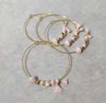 Μαρτυρικά βάπτισης μεταλλικά βραχιόλια στολισμένα με 2 λευκές πέρλες, περίτεχνη ροζ χάντρα  2 χρυσές χάντρες και χρυσό κοχύλι με μεταλλικό χρυσό σταυρό και δερμάτινο ροζ χειροποίητο φιογκάκι.