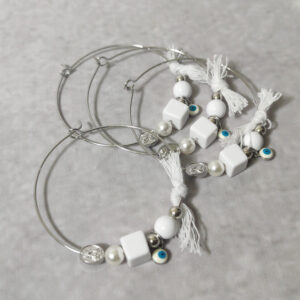 Μαρτυρικά βάπτισης μεταλλικά βραχιόλια στολισμένα με λευκή πέρλα, 2 ασημί χάντρες, τετράγωνη και κυκλική γυαλιστερή χάντρα, ματάκι και χειροποίητο λευκό φιογκάκι.