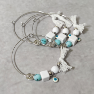 Μαρτυρικά βάπτισης μεταλλικά βραχιόλια στολισμένα με λευκή πέρλα, 2 ασημί χάντρες, τετράγωνη και κυκλική γυαλιστερή χάντρα, ματάκι και χειροποίητο λευκό φιογκάκι.