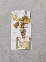 Μαρτυρικά βάπτισης μπρελόκ με λευκές και χρυσές χάντρες, καρδούλα με χάραξη από χρυσό καθρέφτη πλεξι γκλας και διακοσμητικο απο υγρό γυαλί με κοχύλι και φύλλα χρυσού.