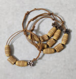 Μαρτυρικά βάπτισης βραχιόλια Boho με διπλό σχοινί και ξύλινες ανάγλυφες χάντρες με μεταλλικό σταυρουδάκι.