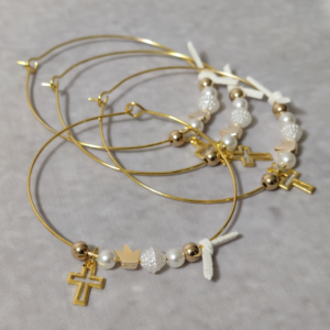 Μαρτυρικά βάπτισης μεταλλικά βραχιόλια στολισμένα με 2 λευκές πέρλες, περίτεχνη λευκή χάντρα  2 χρυσές χάντρες και χρυσή κορώνα με μεταλλικό χρυσό σταυρό και δερμάτινο λευκό φιογκάκι.