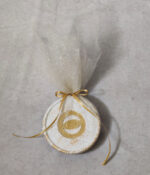 Μπομπονιέρα γάμου σουβέρ κεραμικό με χρυσές πιτσιλιές και μάτι από χρυσό καθρέφτη plexiglass με χάραξη.