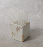 Μπομπονιέρα γάμου κεραμική μολυβοθήκη  σε εκρού χρώμα με χρυσές πιτσιλιλες και λευκό τούλι με γκλίτερ.