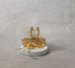 Μπομπονιέρα γάμου κύκνοι από χρυσό καθρέφτη plexi-glass σε βότσαλο.