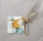 Μπομπονιέρα γάμου κεραμικό σουβέρ εκτυπωμένο με θέμα ευκάλυπτο με τετράγωνο από χρυσό καθρέφτη plexiglass και χάραξη δεμένη με χρυσό γκλίτερ τούλι.