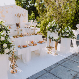 Στολισμός γάμου με λευκή κατασκευή και χρυσά στοιχεία.